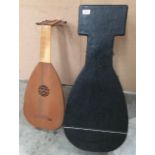 A light wood cased lute plucked string instrument complete with travel case Further