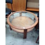 A teak circular glass topped coffee table with woven under tray 82cm dia