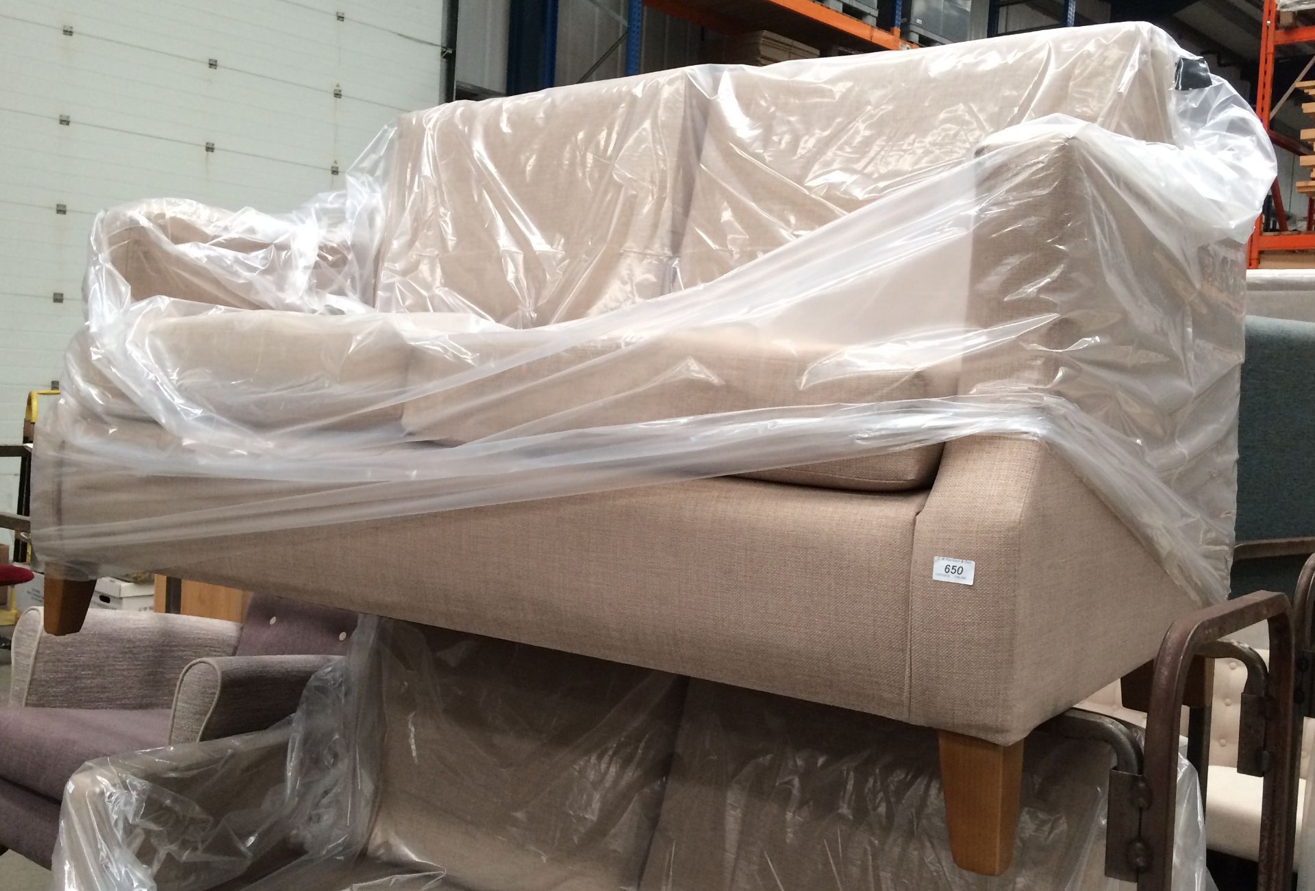 A brown upholstered two seater settee on light wood legs