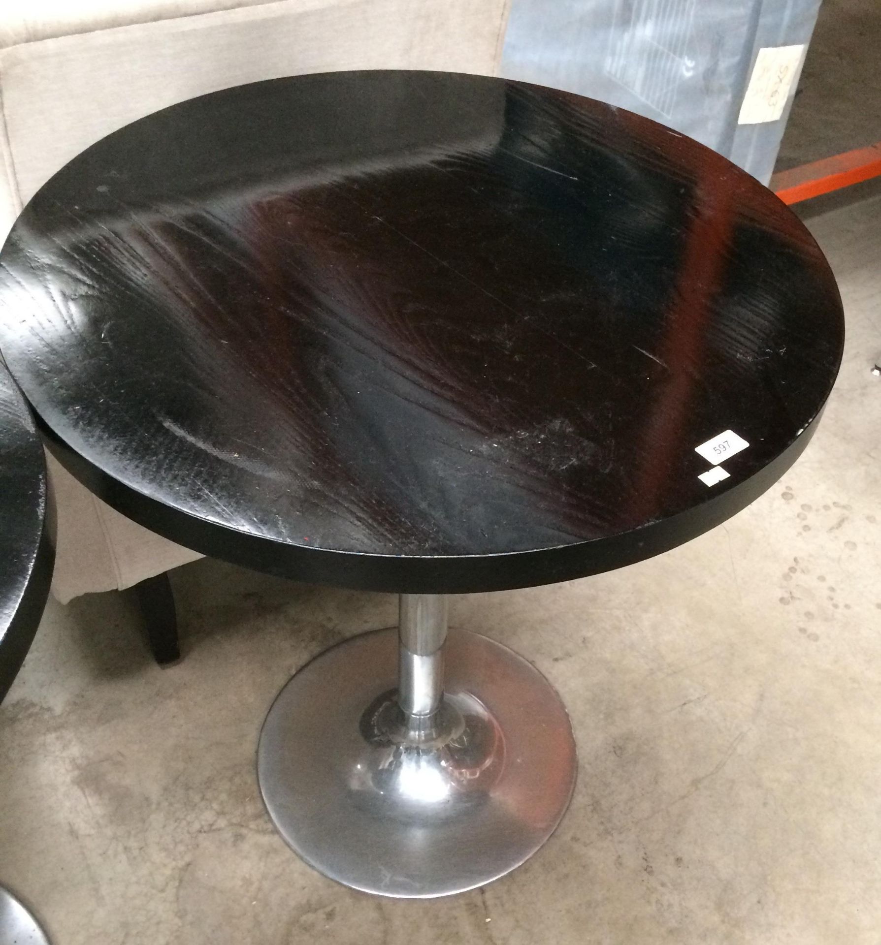 A black wood finish circular cafe table on a single column chrome base 70cm dia