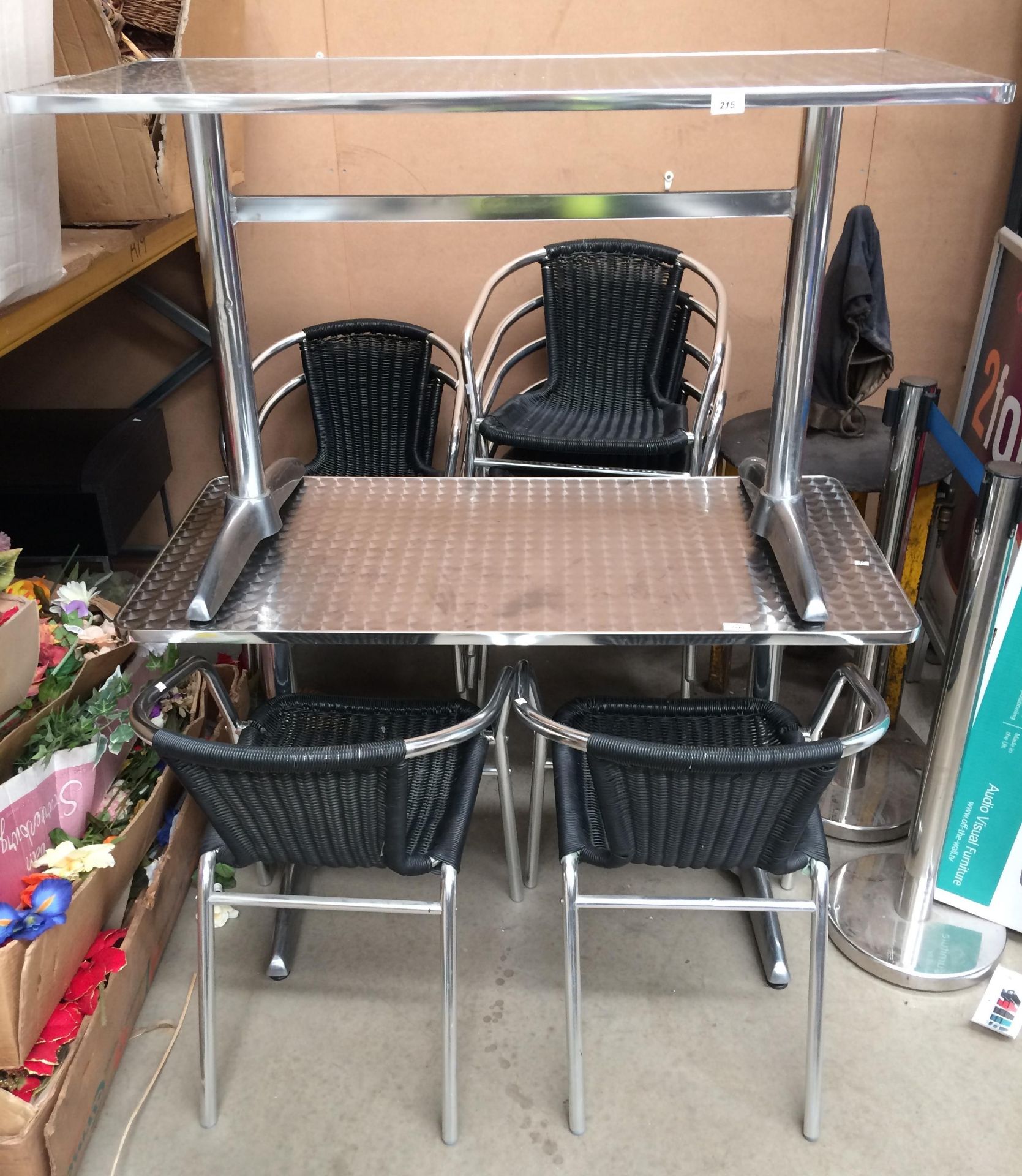 A chrome metal bistro table 60 x 120cm together with four wicker effect armchairs on chrome frames