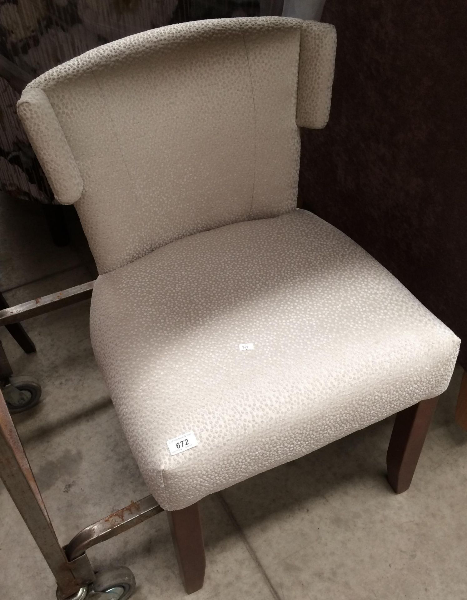 A cream upholstered dressing table chair on dark wood feet