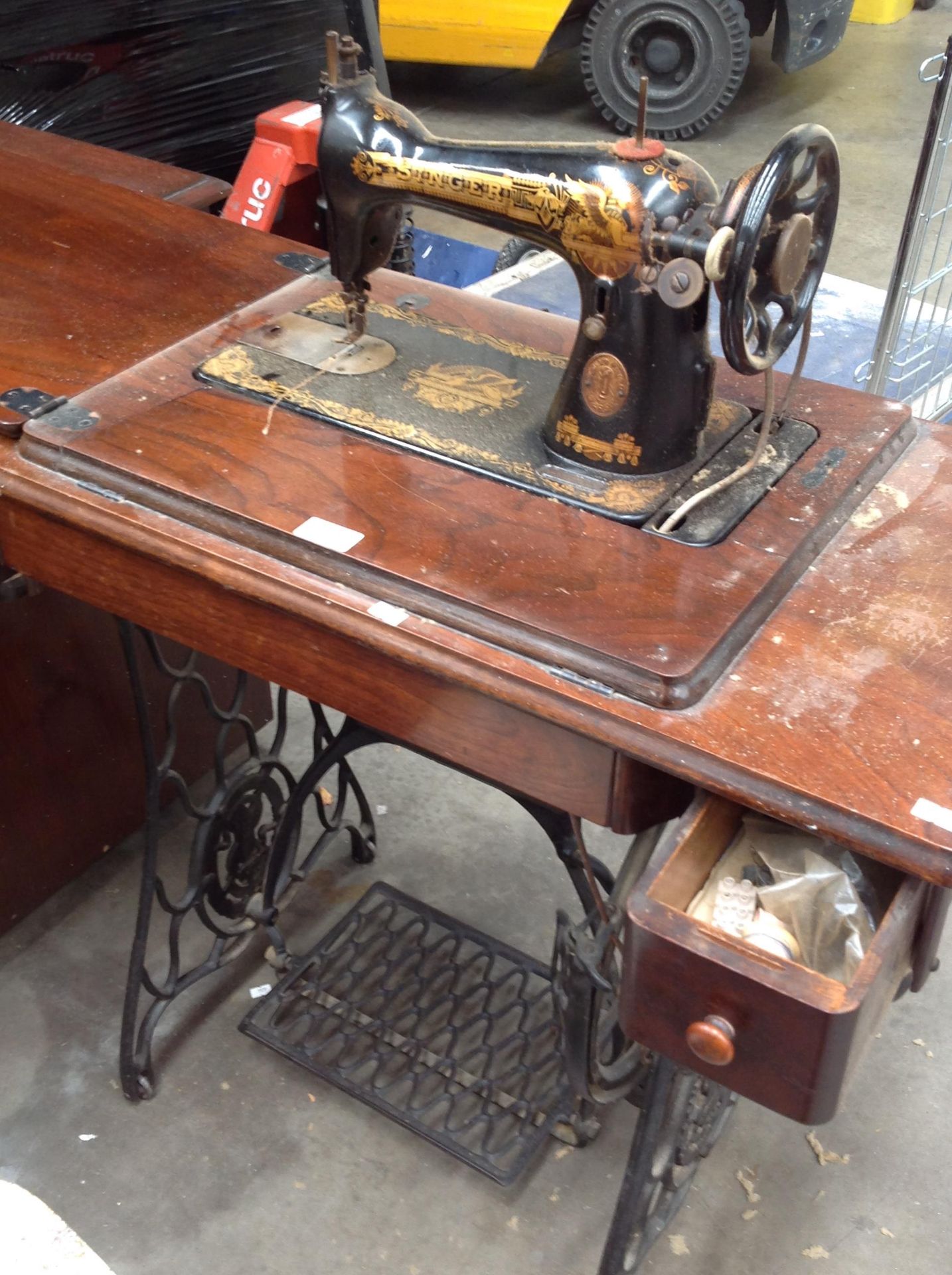 A Singer manual sewing machine wooden cased on a cast metal treadle stand