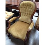 A Victorian mahogany nursing armchair upholstered in a light green deep buttoned material