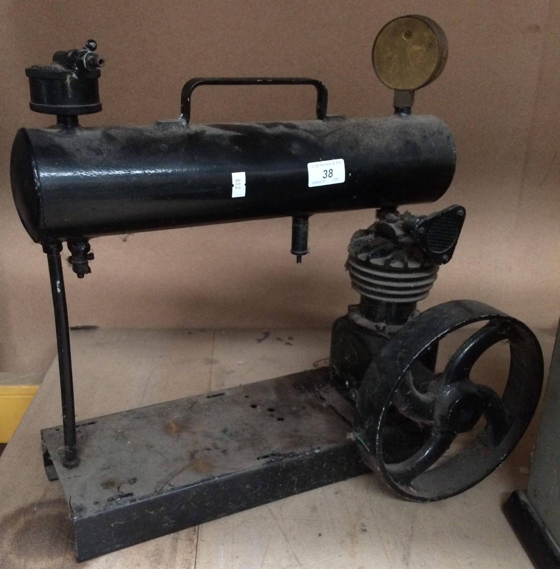 A black metal compressor with brass gauge