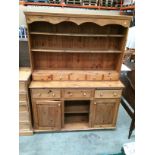 A pine dresser with three open shelves and five spice drawer top section over 3 drawer 2 door base