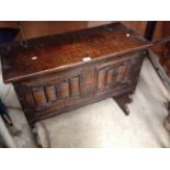 A reproduction oak plank coffer with a carved linen fold front