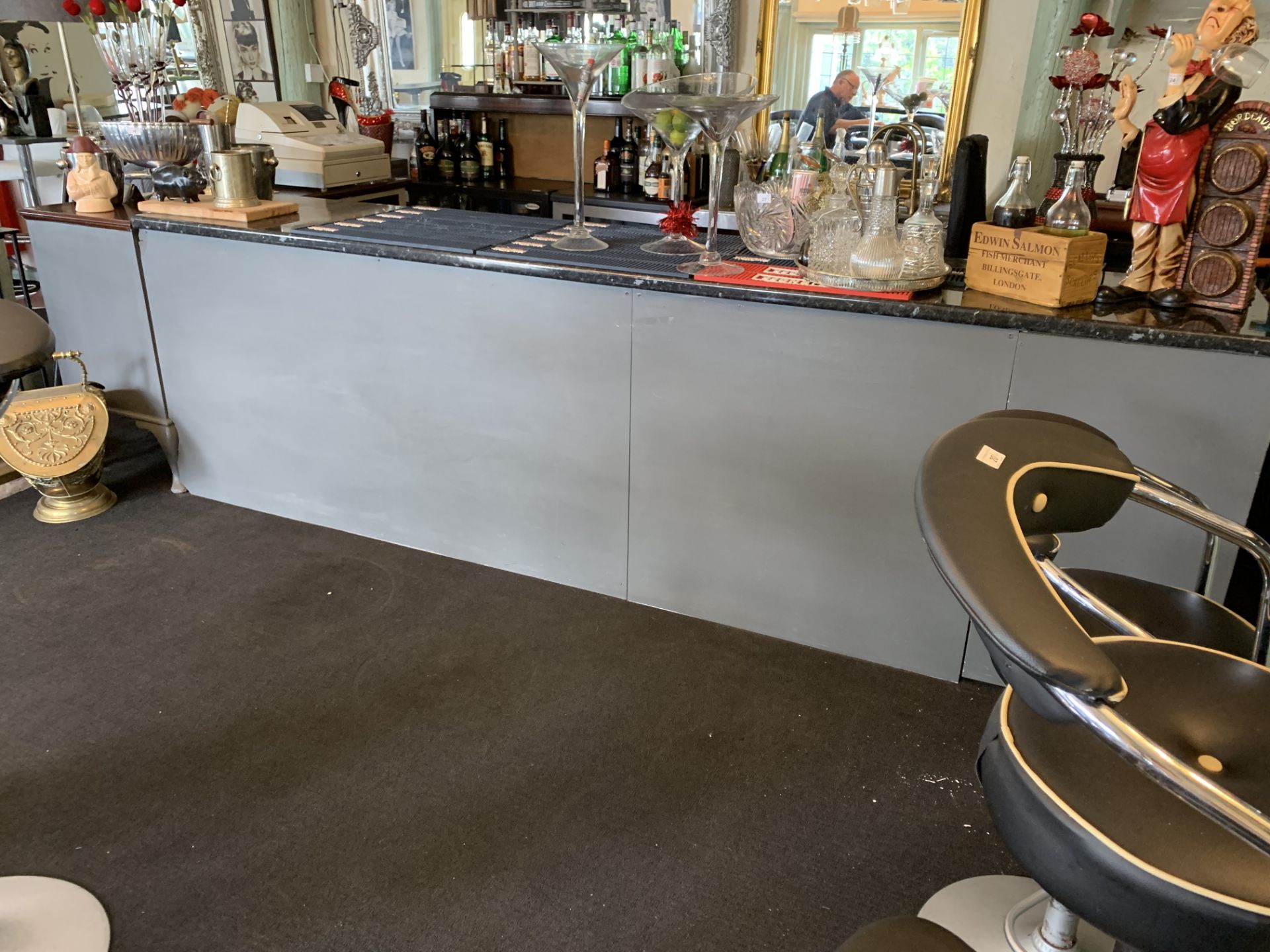 A grey painted long bar with black marble effect work top incorporating a sideboard and storage