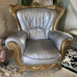 An ornate gilt framed armchair with silver sprayed upholstery