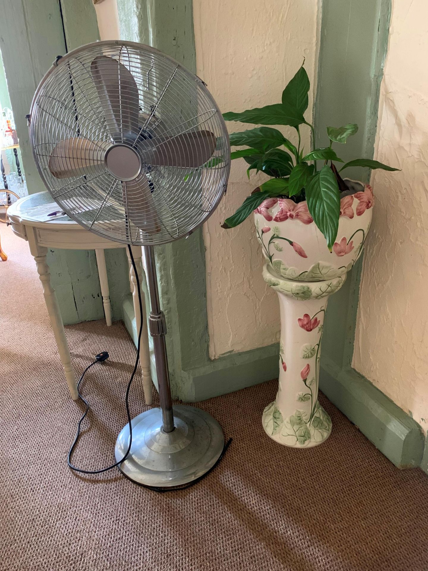 A white floral patterned jardiniere on pedestal and a freestanding oscillating fan (2)