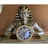 A fibre glass silver and gilt Pharaoh mantel clock 66cm wide