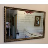 Gilt framed wall mirror with painted floral decoration, gilt framed wall mirror, table lamp,