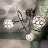 A modern chrome framed ceiling light with glass ball shades