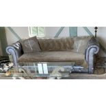 A silver spray painted deep buttoned back Chesterfield settee with brown throws