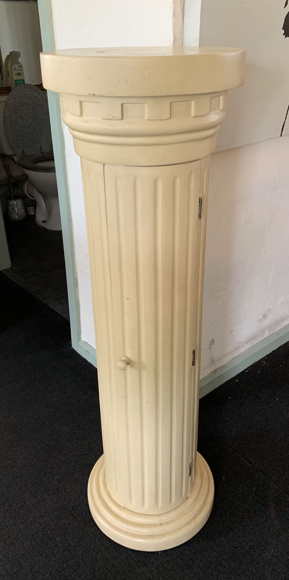 A beige painted free standing plinth/CD cabinet