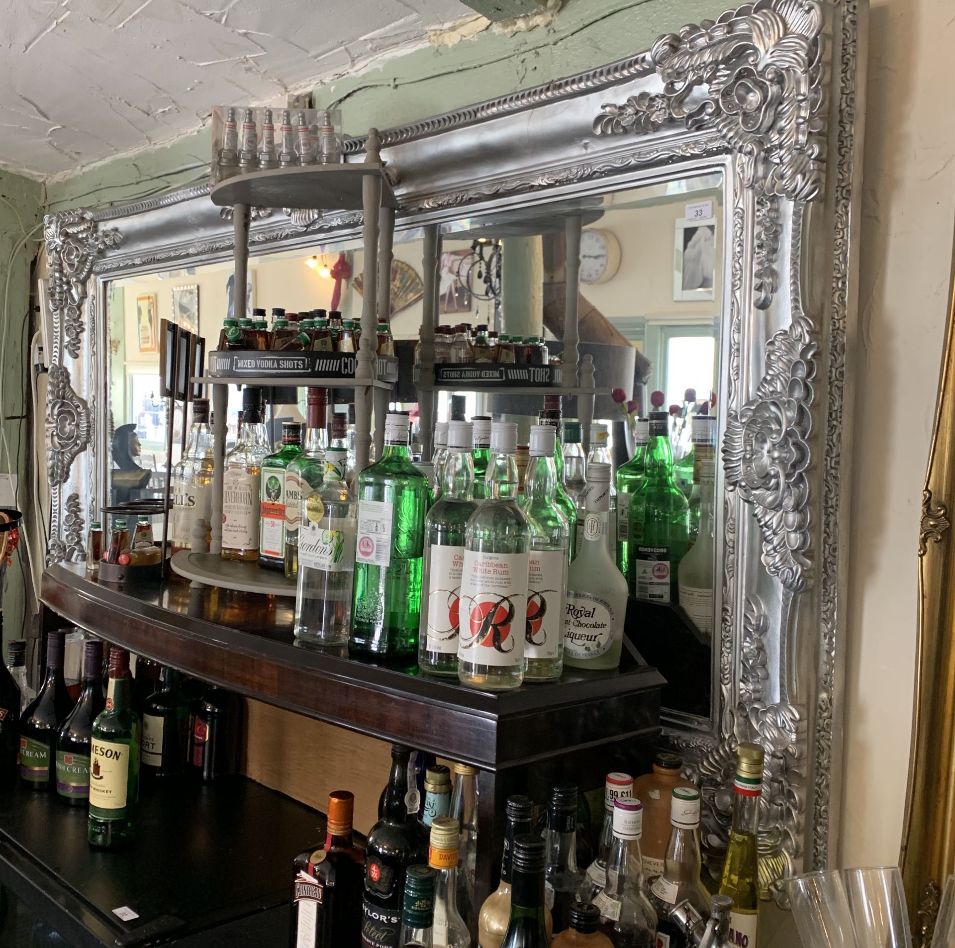 An ornate silver painted wall mirror