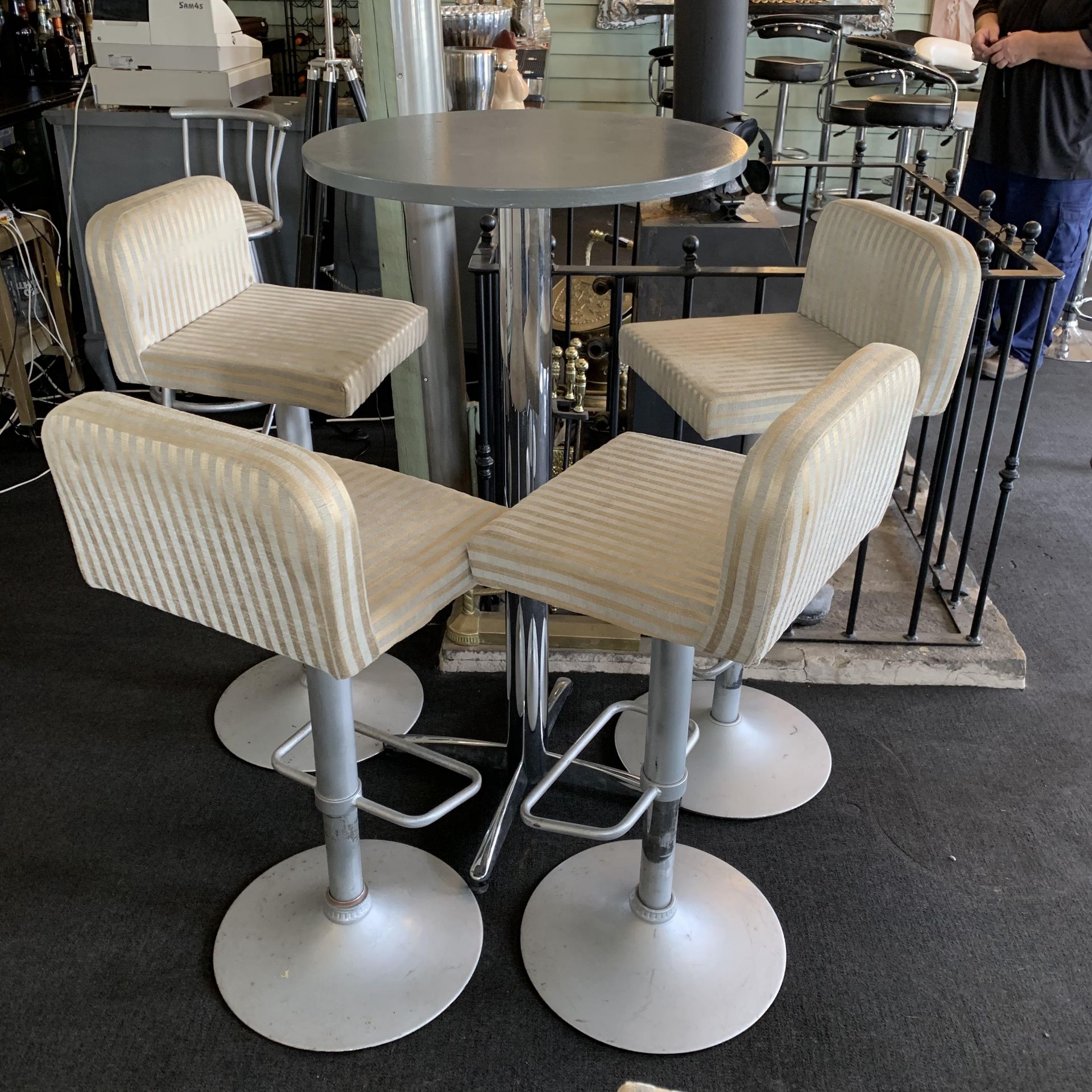 A chrome framed high bar table with grey painted top 60cm diameter and four sprayed chrome framed