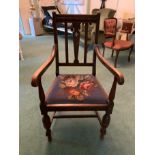 An oak framed armchair with floral patterned upholstered seat