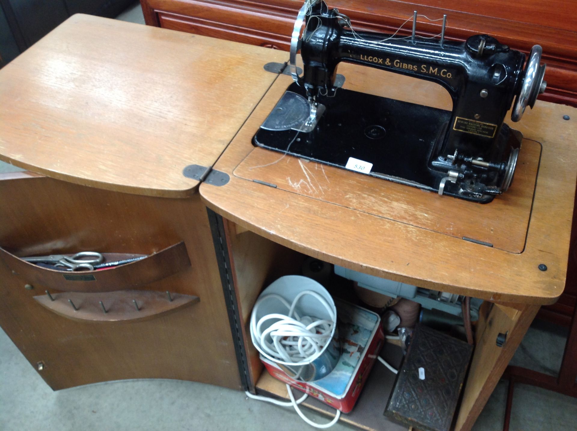 A Wilcox and Gibbs vintage electric sewing machine complete with foot pedal in oak finish case,