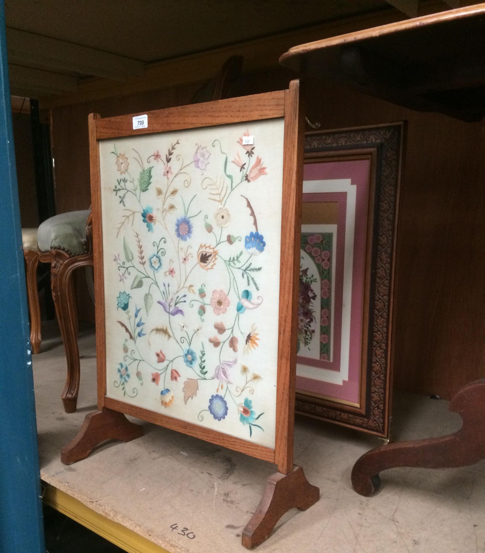 An oak framed embroidered fire screen an