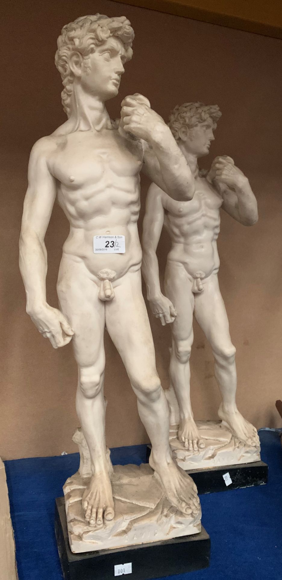 Two plaster statues of David on plinths each 67cm high