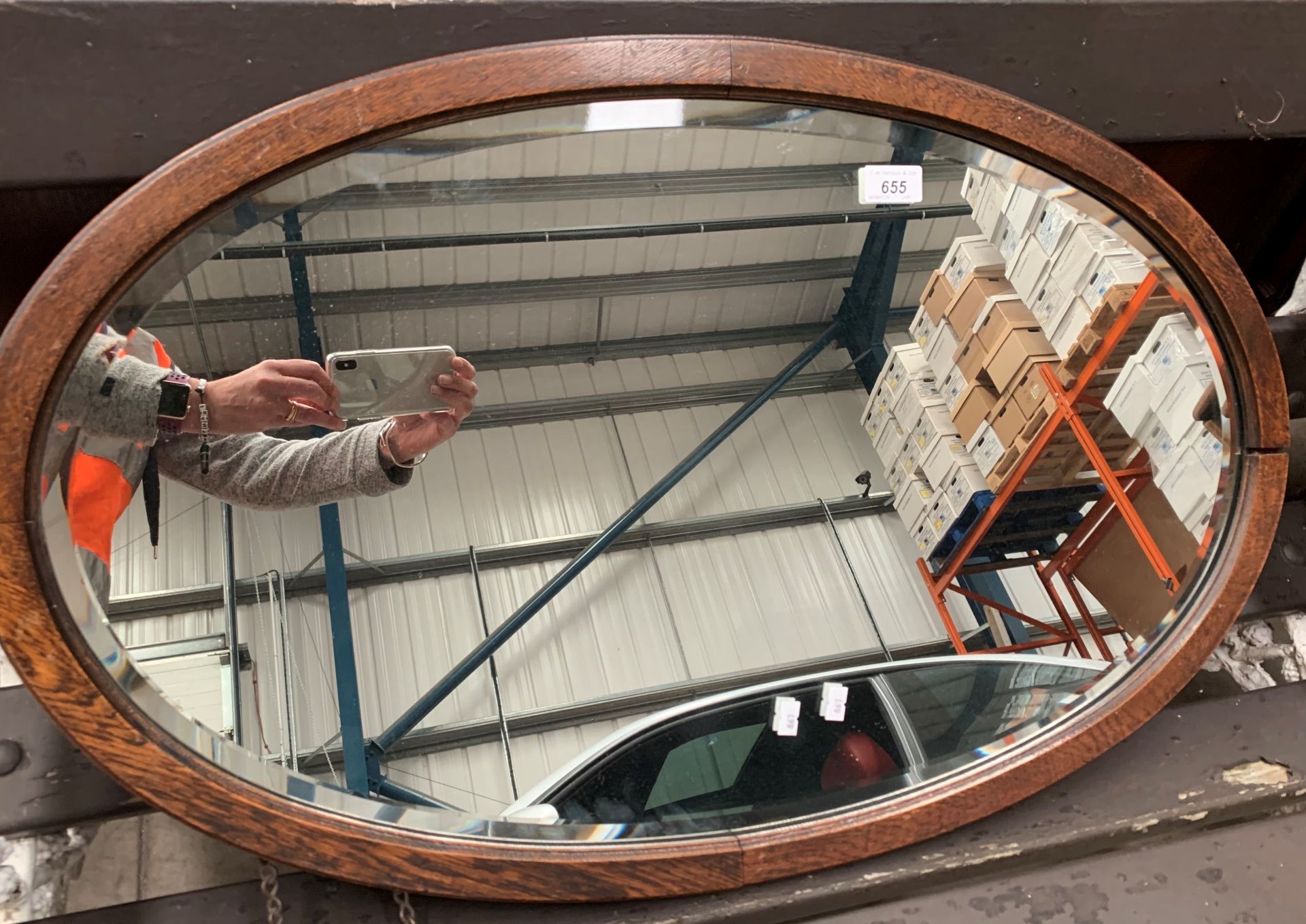 An oak framed oval wall mirror