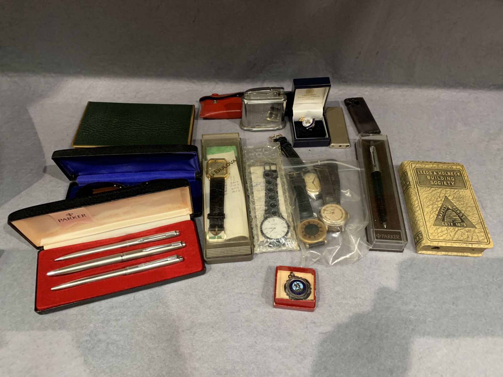 A small collection of modern gentlemen's wrist watches, cigarette lighters, pen and pencil set,