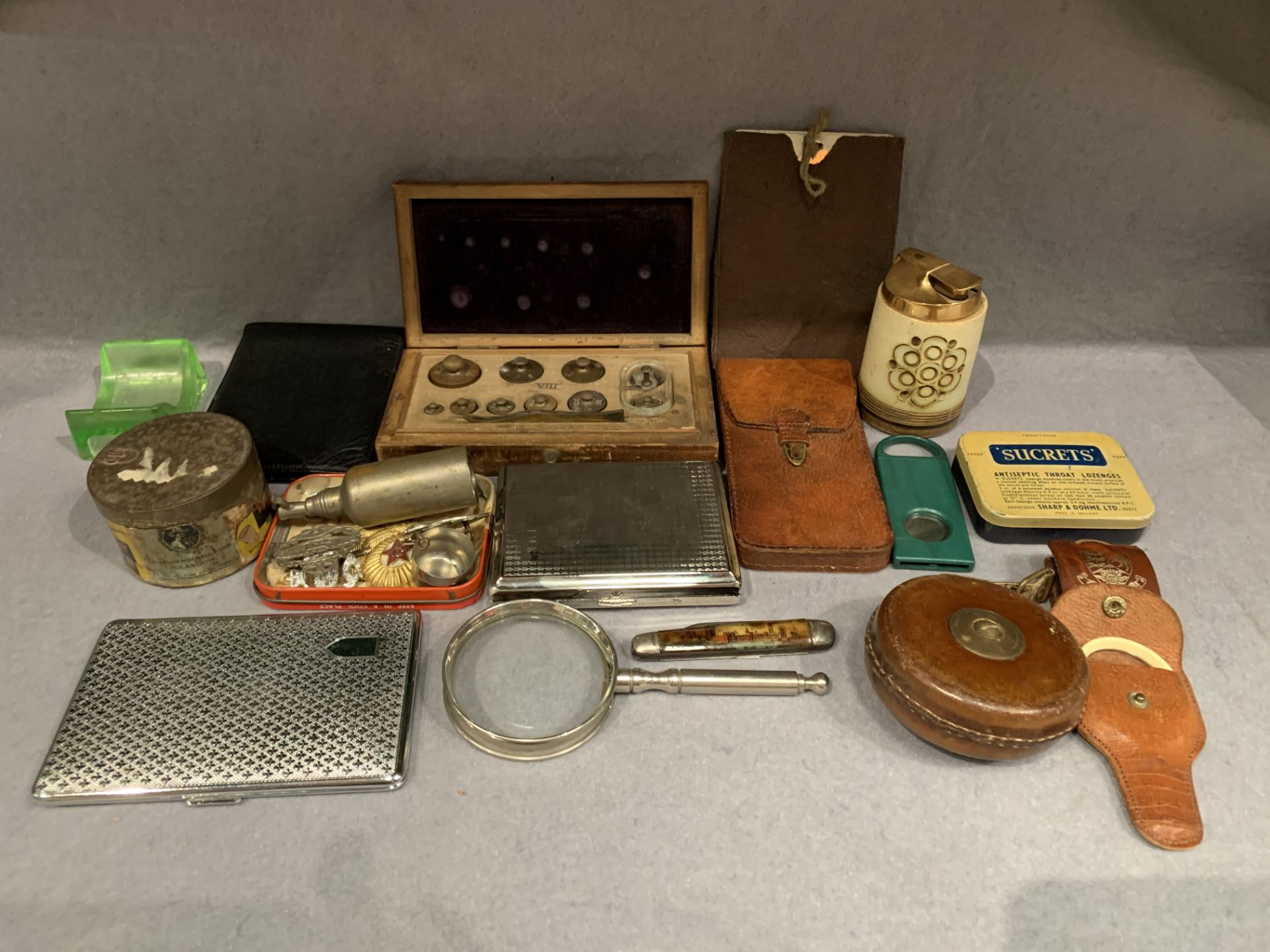 Assorted cigarette cases, vintage tins, military badges, cased laboratory scale weights,