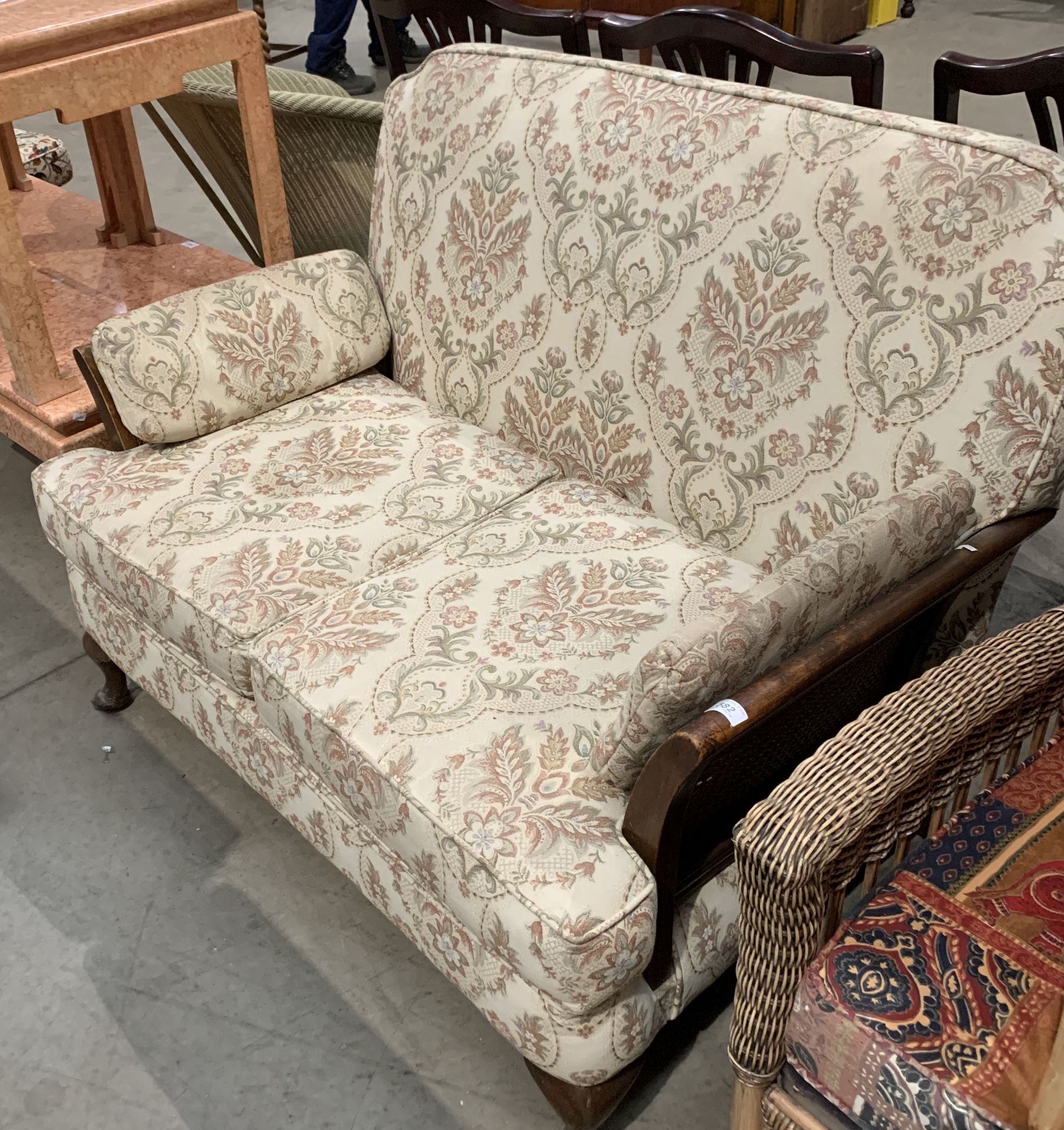 A Bergere style framed two seater settee with light brown patterned upholstery