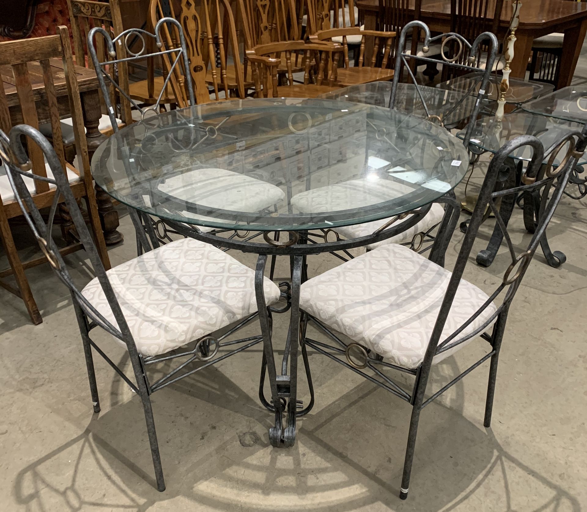 A metal framed circular dining table with glass top 106cm diameter complete with four matching