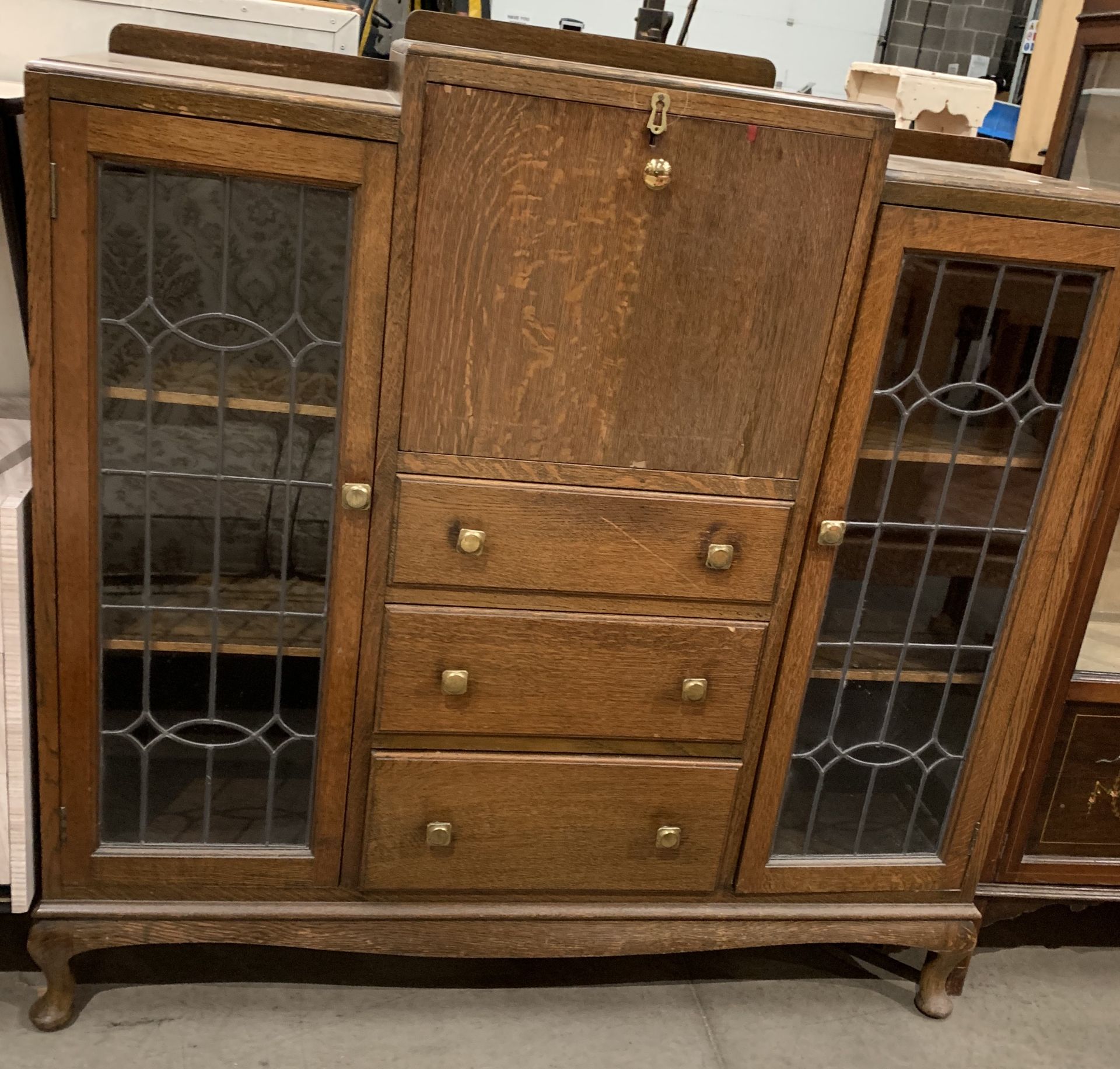 An oak bureau display cabinet with fall flap over three drawer centre flanked by two leaded glazed