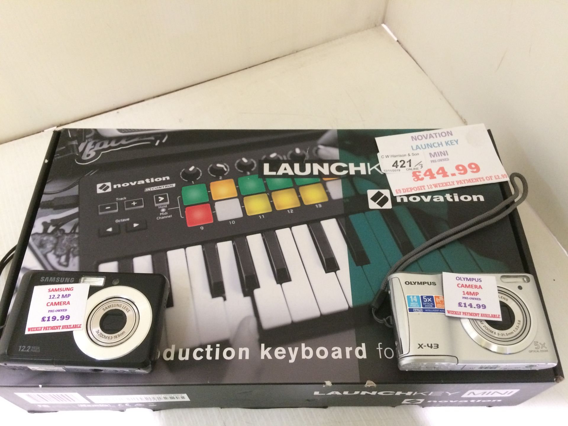 Novation Launch Key Mini and two assorted cameras by Olympus and Samsung.