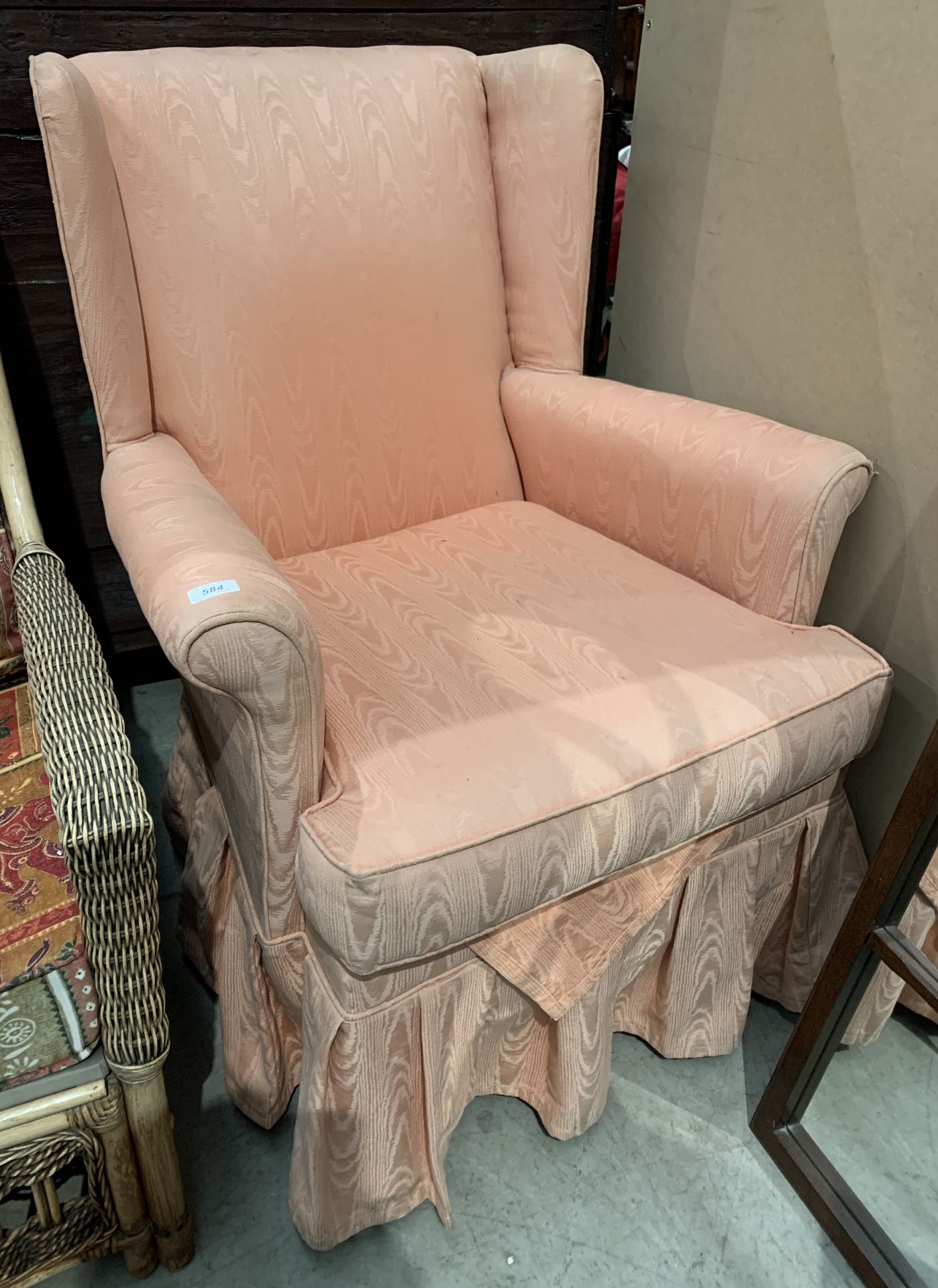 A pink cloth upholstered wing back armchair