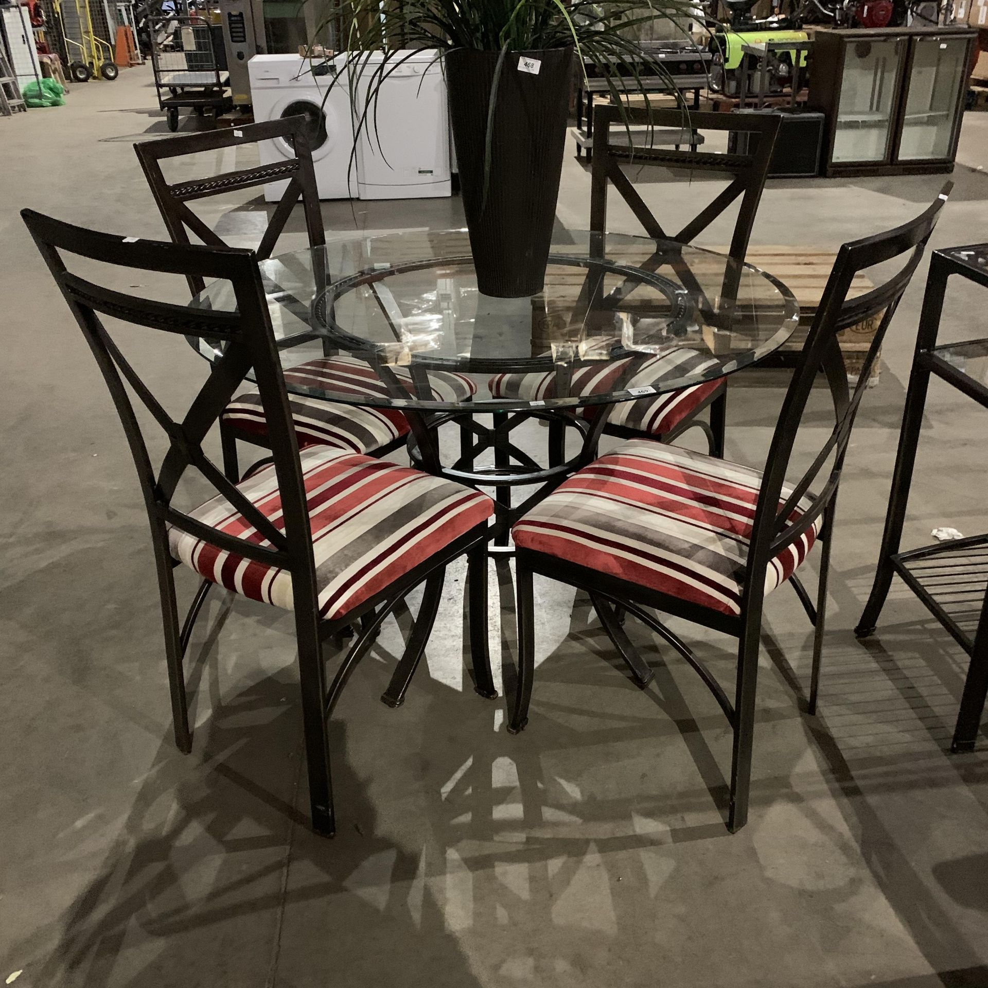 A circular glass topped dining table 115cm diameter on metal frame 4 matching chairs with striped