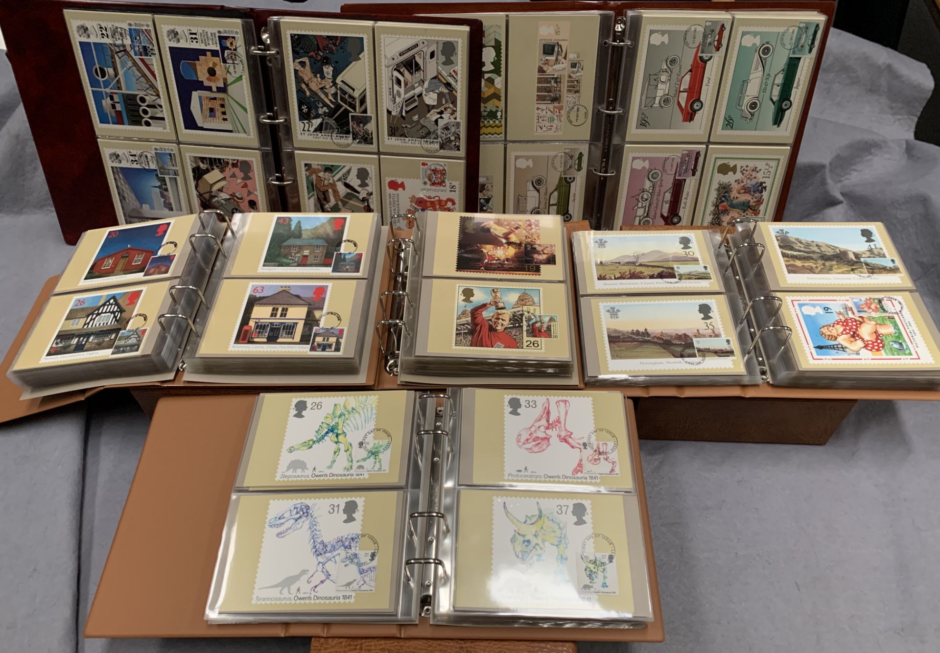 Six folders containing a collection of Royal Mail postcards featuring a variety of stamp designs