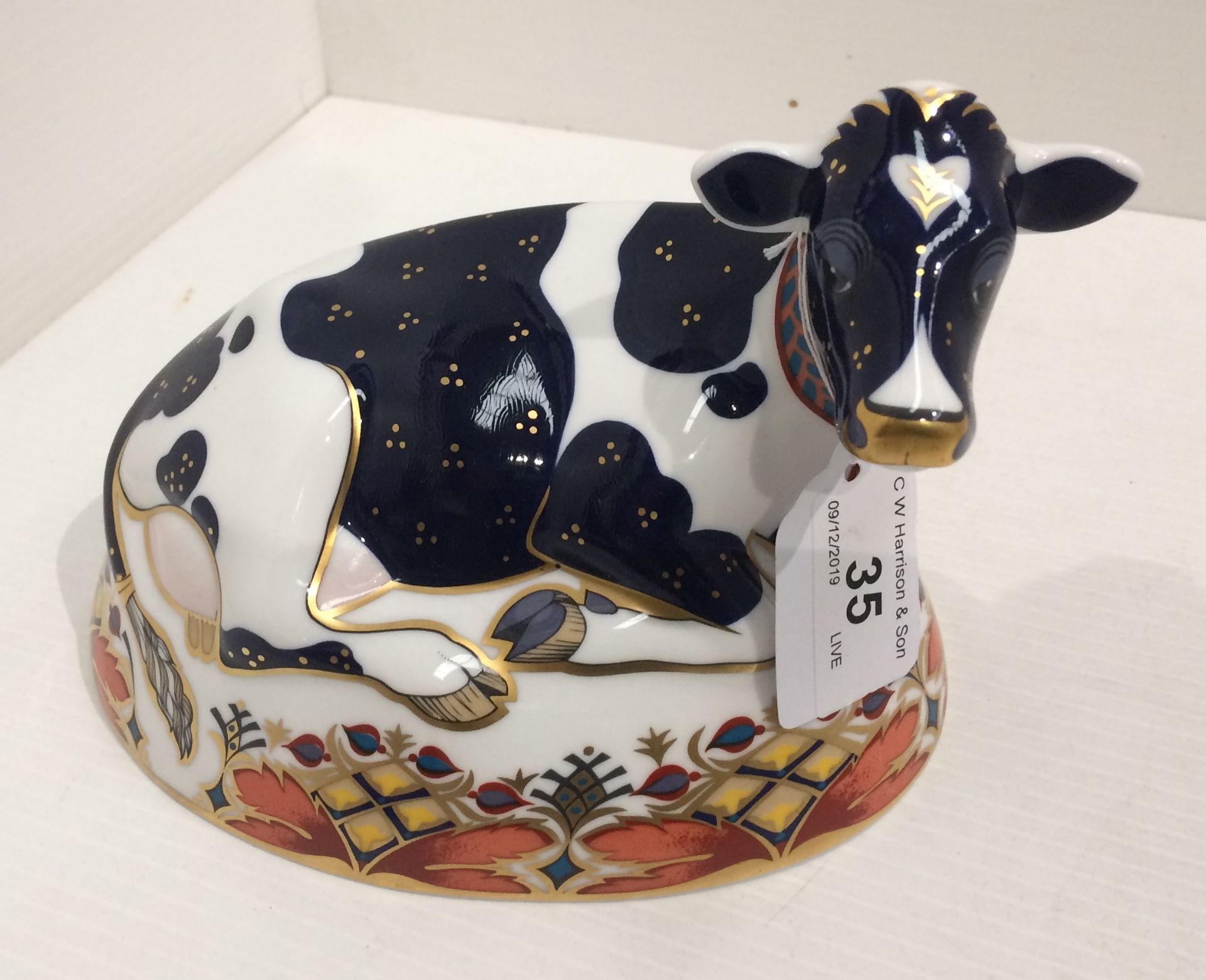 A Royal Crown Derby bone china Friesian Cow Buttercup paperweight - 18cm long