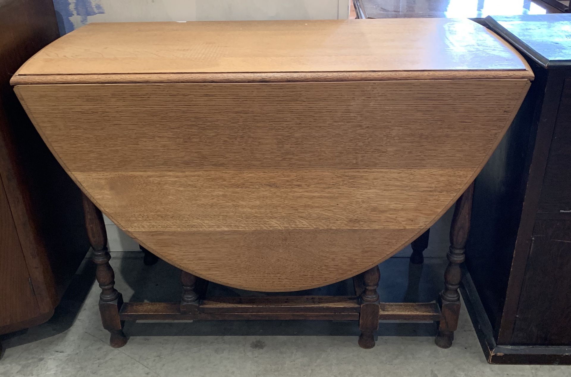 An oak oval drop leaf dining table 108 x 160cm when extended - stamped to wood underside Waring and