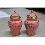 A pair of salmon pink and gilt Royal Crown Derby covered vases,