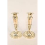 A pair of early 19th Century French brass and copper candlesticks with fluted and chased decoration,