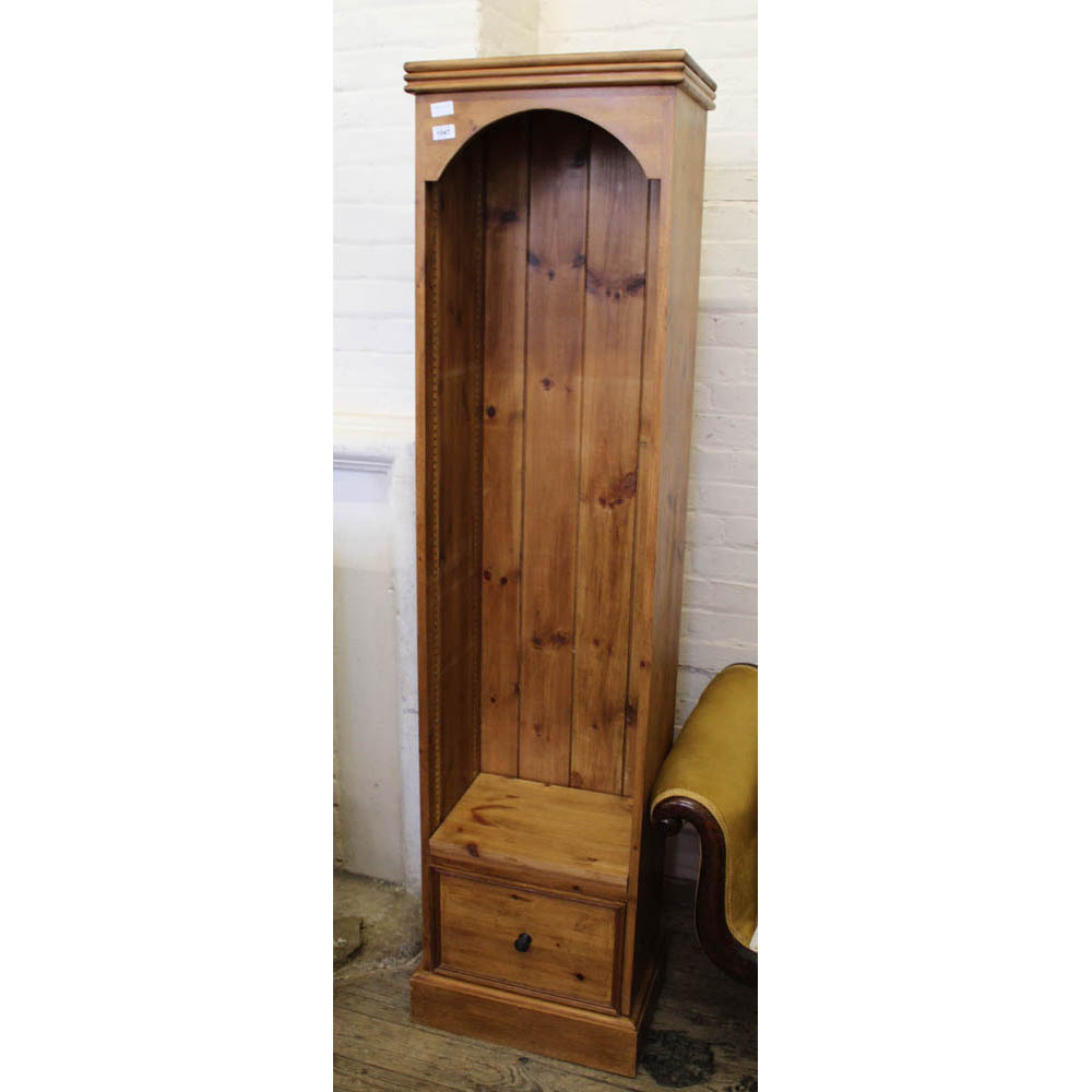 A narrow modern pine shelf unit with drawer below