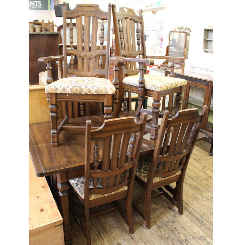 An oak extending dining table with six upholstered dining chairs including two carvers