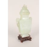 A Chinese jade lidded vase with loose ring handles, floral carving and bird finial,