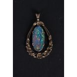 A large 9ct gold pendant with floral decoration with oval shaped opal doublet to centre