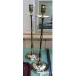 A pair of tall Edwardian brass candlesticks with drip trays, slender stems and circular bases,