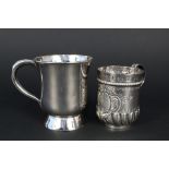 An ornate silver christening mug with embossed rubbed detail ornately decorated cartouche,