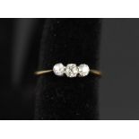 An 18ct gold three stone diamond ring (marks rubbed) size M