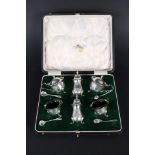 A six piece silver cruet set in fitted box with wavy rim detail by Mappin & Webb with four