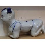 A Chinese porcelain blue decorated headrest in the form of a knelling boy,