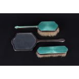 Three piece silver dressing table set with green enamel decoration (some losses to enamel)