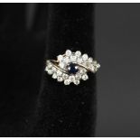 A 9ct gold ring set with central sapphire and white stone cluster border,